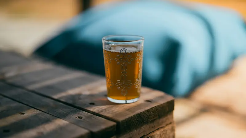 A glass of tea on a table, at home.